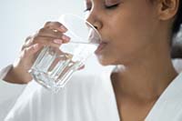 Photo of a woman drinking a glass of water